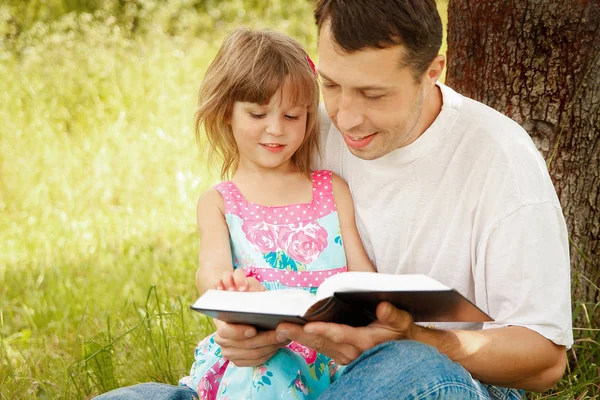 Junger Vater liest mit seiner kleinen Tochter die Bibel — Stockfoto