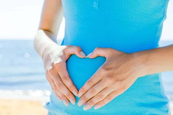 Gelukkig mooie zwangere vrouw aan de zee in de zomer op de n — Stockfoto