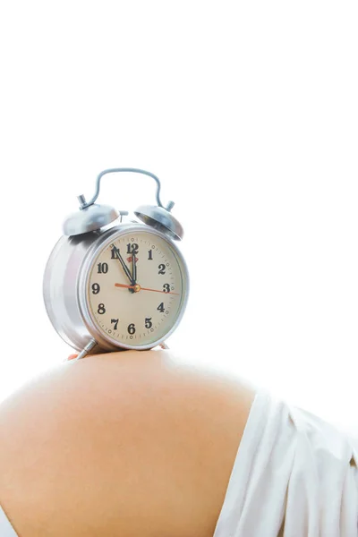 Hermosa joven embarazada sobre un fondo blanco con alarma c — Foto de Stock