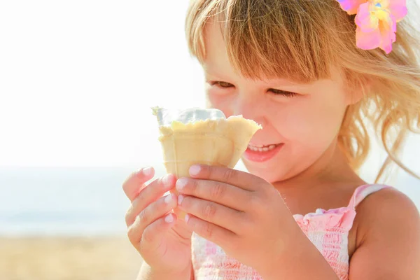 Happy baby girl on the sea in summer eating ice cream outdoors — Stock Photo, Image