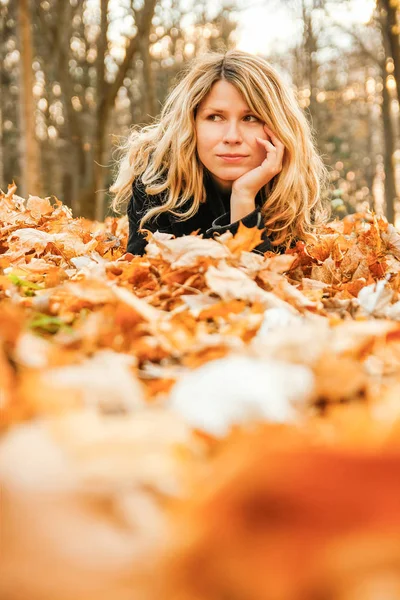 Happy woman on the leaves of autumn in nature — Stock Photo, Image