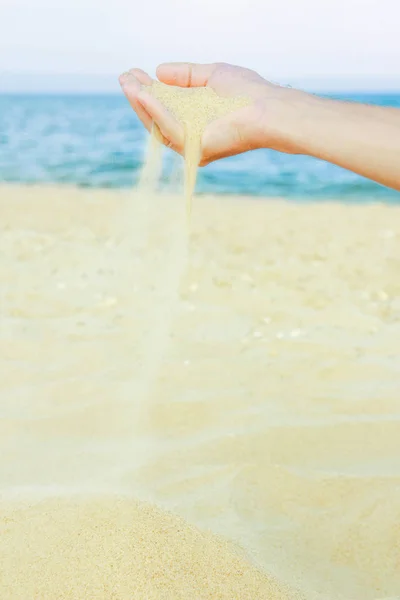 Gelukkige kerel giet zand uit de zee van de handen — Stockfoto