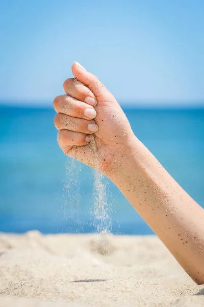 Manos están vertiendo arena junto al mar —  Fotos de Stock