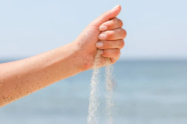 Hand på havet häller sand på naturen — Stockfoto