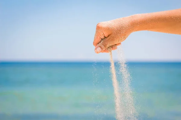 Hands are pouring sand by the sea — Stock Photo, Image