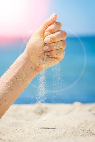 Händer häller sand vid havet — Stockfoto