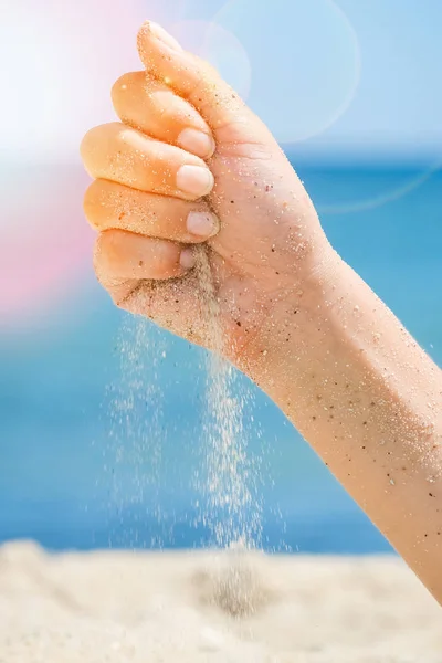 As mãos estão derramando areia pelo mar — Fotografia de Stock