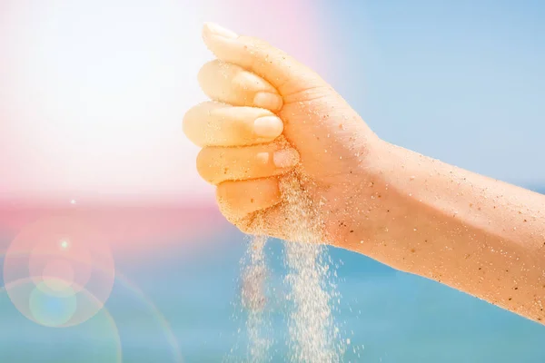 Τα χέρια χύνουν άμμο δίπλα στη θάλασσα — Φωτογραφία Αρχείου