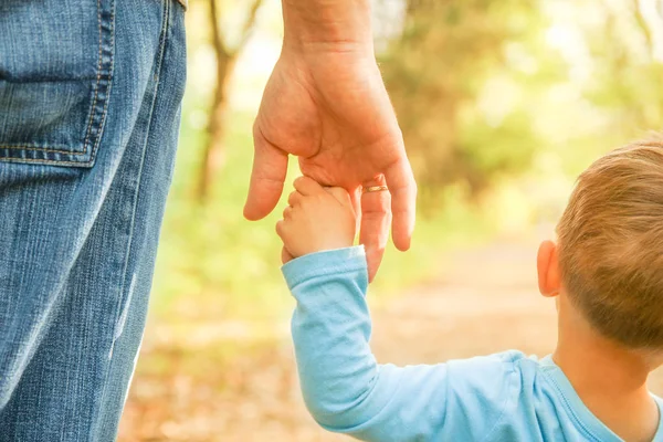 O pai segurando a mão da criança com um fundo feliz — Fotografia de Stock