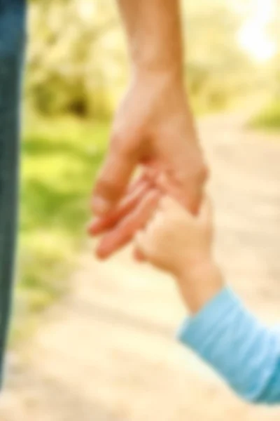 带着幸福的背景牵着孩子的手的父母 — 图库照片