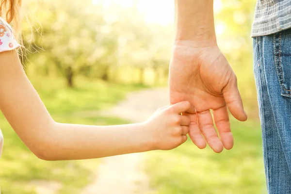 Der Elternteil hält die Hand des Kindes mit einem glücklichen Hintergrund — Stockfoto