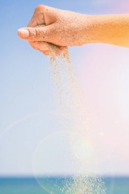 Denizin kenarından kumlar dökülüyor