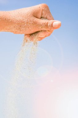 Denizin kenarından kumlar dökülüyor