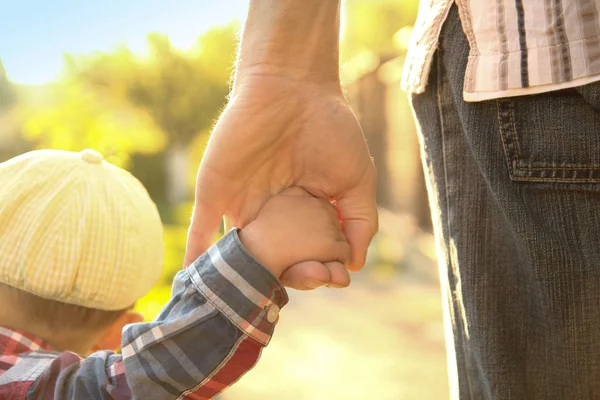 De ouder die de hand van het kind met een gelukkige achtergrond vasthoudt — Stockfoto