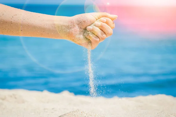 As mãos estão derramando areia pelo mar — Fotografia de Stock