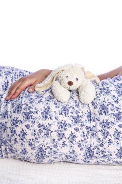 Mutlu hamile kız beyaz arka planda yatıyor.