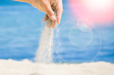 Denizin kenarından kumlar dökülüyor