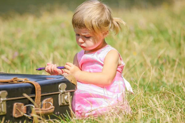 Bébé fille heureuse avec une valise à l'extérieur au parc — Photo
