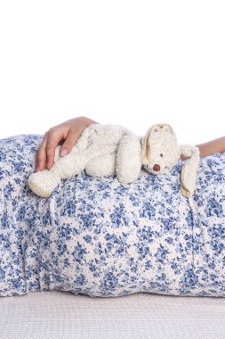 Mutlu hamile kız beyaz arka planda yatıyor.