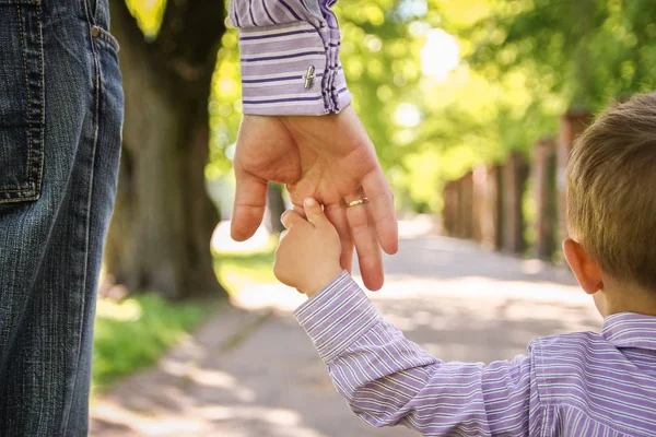 De ouder die de hand van het kind met een gelukkige achtergrond vasthoudt — Stockfoto