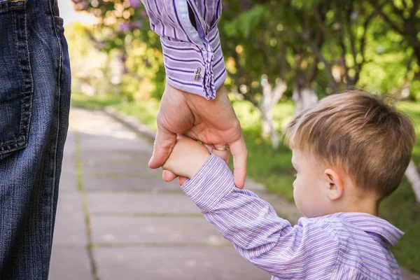 De ouder die de hand van het kind met een gelukkige achtergrond vasthoudt — Stockfoto