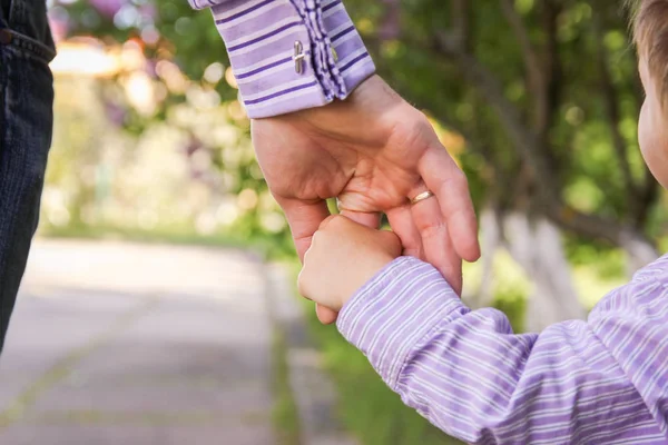 De ouder die de hand van het kind met een gelukkige achtergrond vasthoudt — Stockfoto