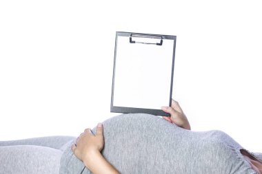 Mutlu hamile kız beyaz arka planda yatıyor.