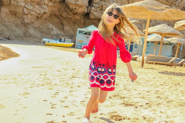 Gelukkig kind trekt op het zand in de buurt van de zee achtergrond — Stockfoto