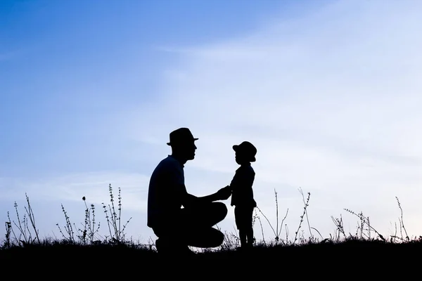 Genitore felice con bambini che giocano sulla silhouette estiva della natura — Foto Stock