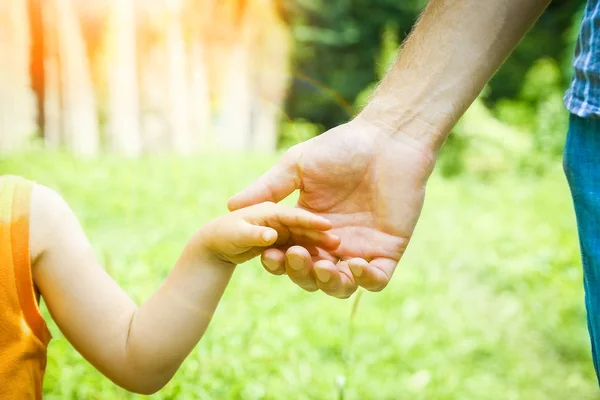 Schöne Hände eines Kindes und eines Elternteils in einem Park in der Natur — Stockfoto