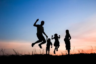 Mutlu aile doğada oynuyor yaz siluetinde