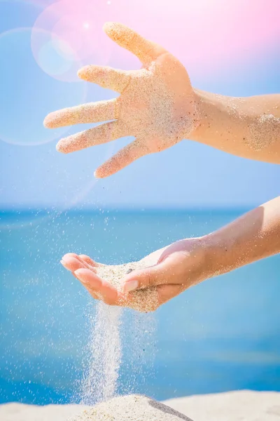 As mãos estão derramando areia pelo mar — Fotografia de Stock