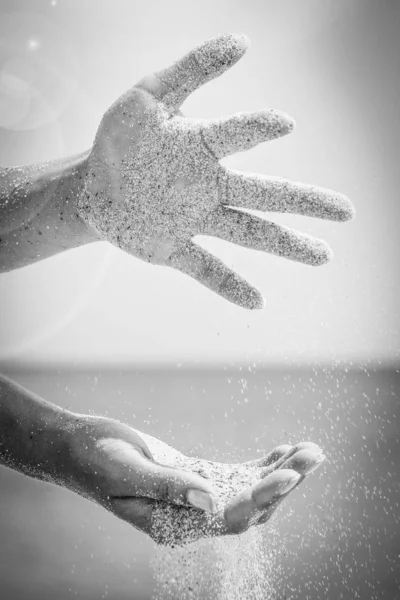 Händer häller sand vid havet — Stockfoto