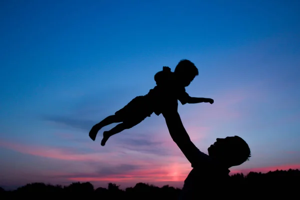 Glückliche Eltern mit Kindern spielen auf Natur Sommer Silhouette — Stockfoto