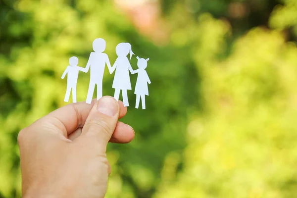 In de handen van de familie op een achtergrond papier — Stockfoto