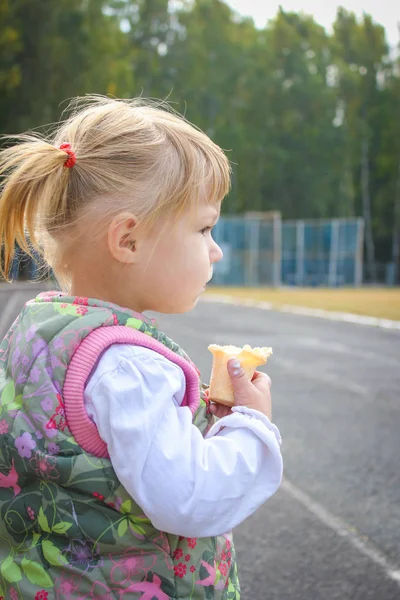 Šťastné dítě jíst zmrzlinu na přírodní park ve městě — Stock fotografie