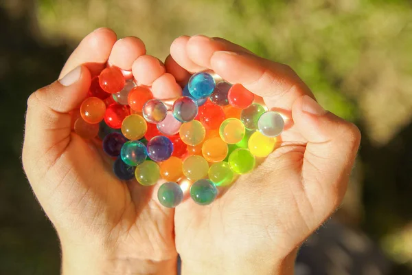 Fin bakgrund av olika färger bollar i händerna — Stockfoto
