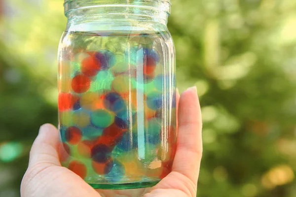 Mooie achtergrond van verschillende kleuren ballen in handen — Stockfoto