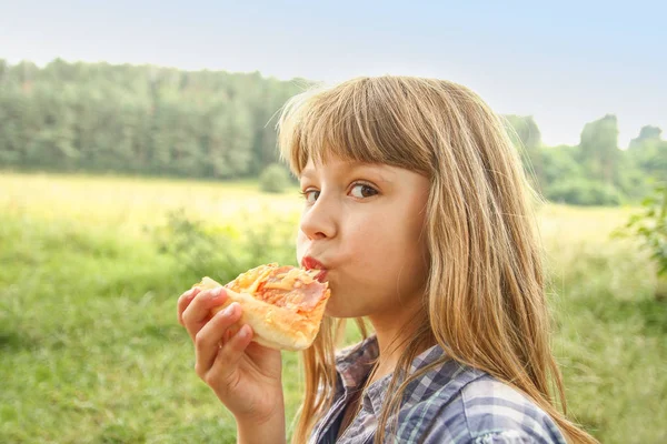 Dítě jíst chutné pizzy na charakteru trávy v par — Stock fotografie