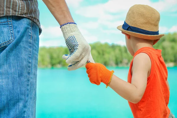 Hands of a parent and child in nature in a park by the sea — Stock Photo, Image