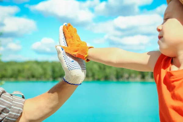 Hands of a parent and child in nature in a park by the sea — Stock Photo, Image