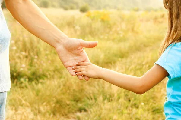 Handen van ouder en kind in de natuur — Stockfoto