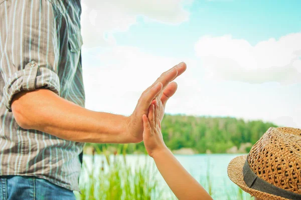 Hands of a parent and child in nature in a park by the sea — Stock Photo, Image