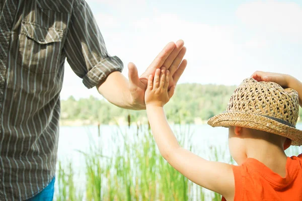 Hands of a parent and child in nature in a park by the sea — Stock Photo, Image