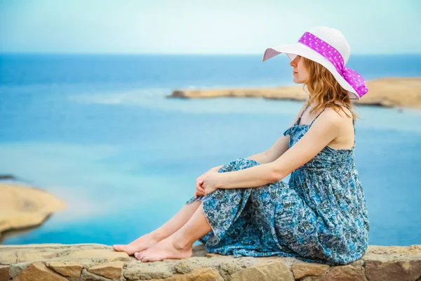 Stijlvol mooi meisje met hoed op de kust achtergrond — Stockfoto