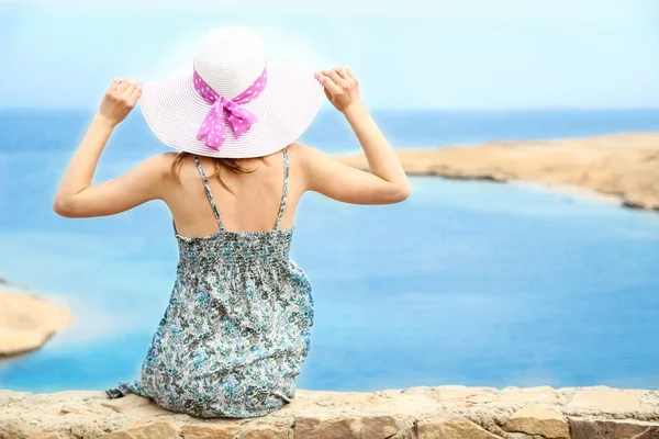 Stijlvol mooi meisje met hoed op de kust achtergrond — Stockfoto