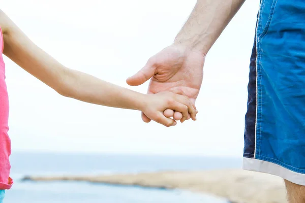 Belle mani di genitore e figlio su sfondo mare — Foto Stock