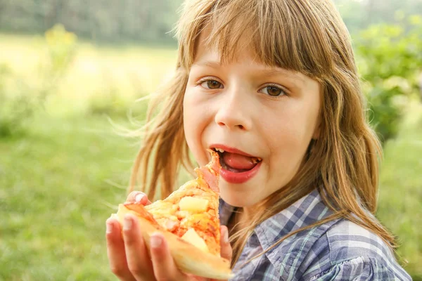 Dítě jíst chutné pizzy na charakteru trávy v par — Stock fotografie