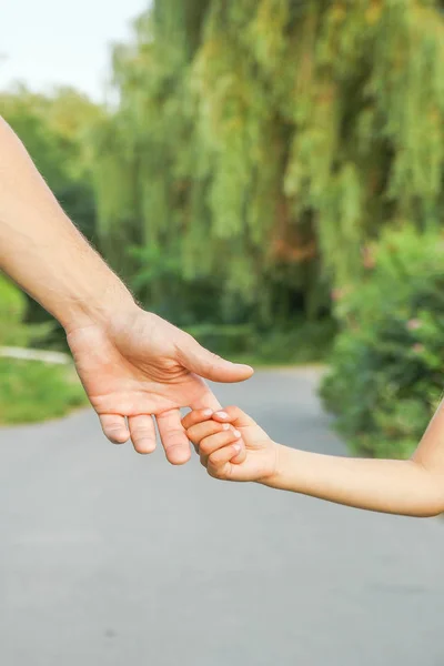 Il genitore che tiene la mano del bambino con uno sfondo felice — Foto Stock