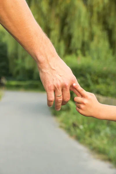 El padre sosteniendo la mano del niño con un fondo feliz —  Fotos de Stock
